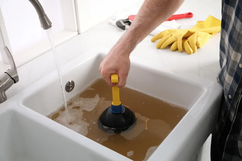 Addressing a gurgling but still draining sink with a plunger, a common plumbing issue Drain Pros Venture can resolve.