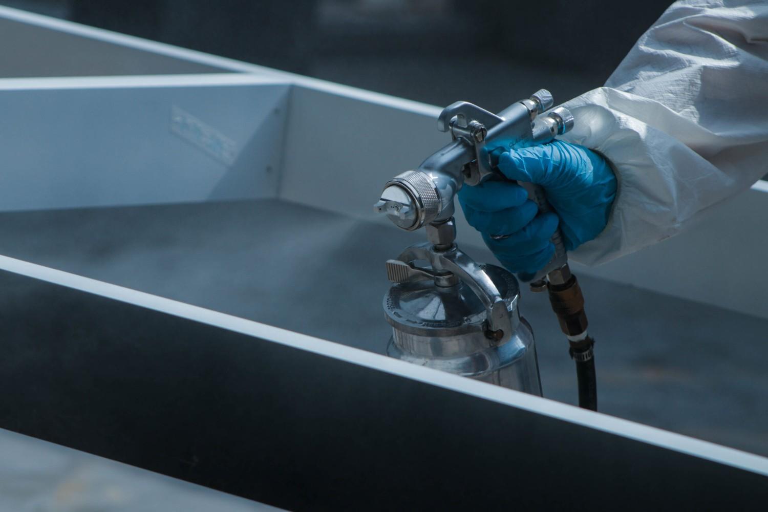 A high-quality finish being applied with a spray gun, indicating attention to detail and excellent results. Drain Pros Ventura strives for similar quality in all their plumbing services in Ventura.